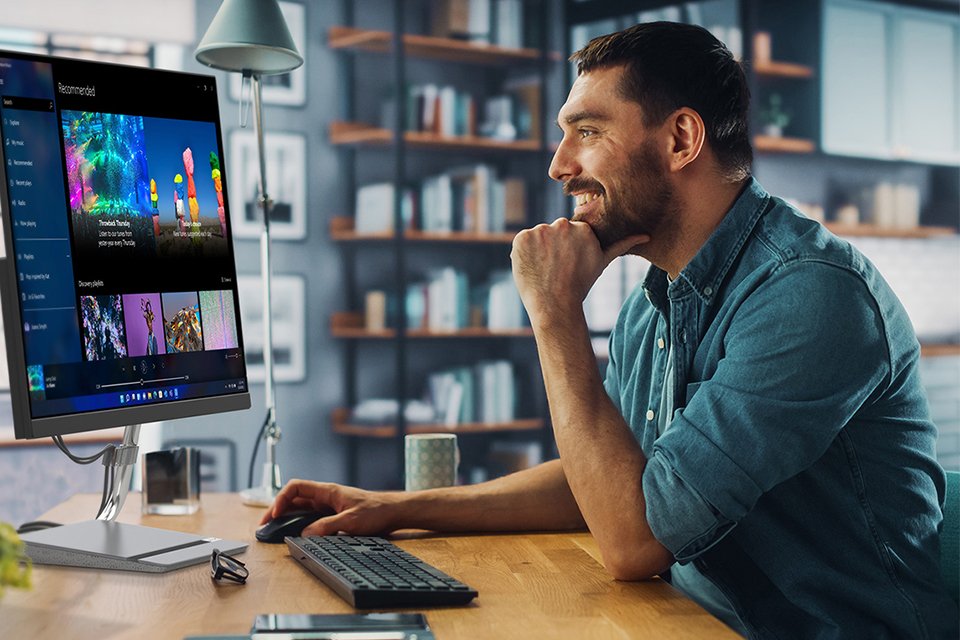 Man smiling using a Lenovo monitor.