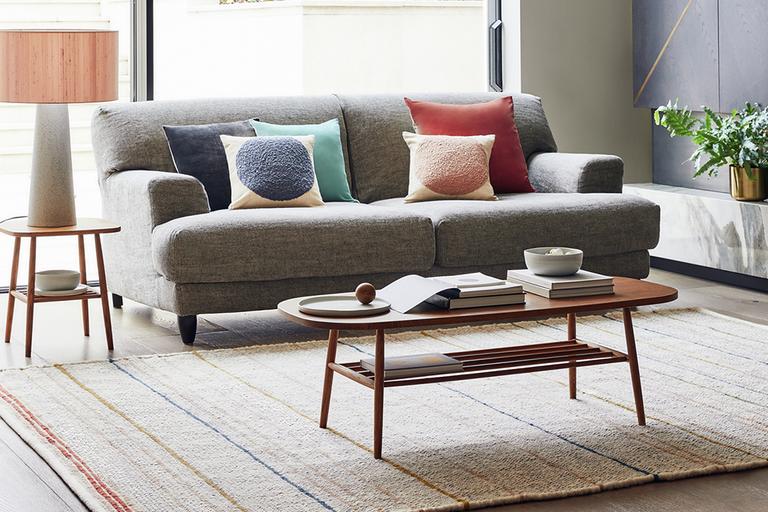 A living room with oak coffee table and grey sofa.
