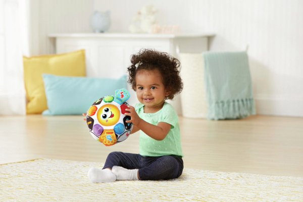 A baby pulling a toy along.