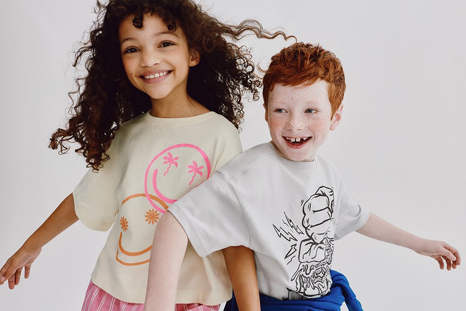 girl and boy smiling wearing t-shirts.
