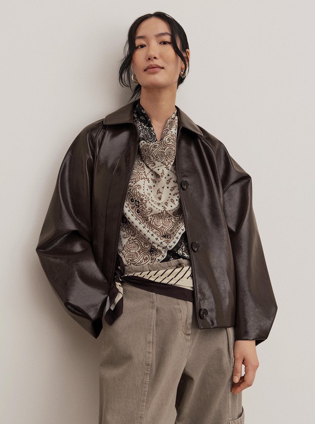 Women wearing dark brown PU jacket with a striped top and jeans.