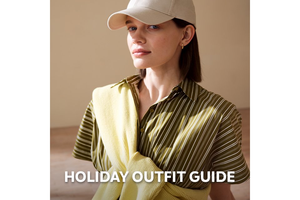 Person wearing a green striped shirt dress with a yellow knit sweater styled over the shoulders.