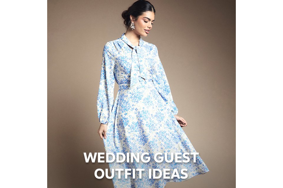 Blue floral midi dress with long sleeves and tie‑neck detail styled for spring wedding season.