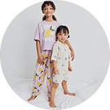 Girl wearing unicorn‑print pyjamas from the girls’ nightwear collection.