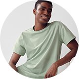 Person sitting in grey top and dark pyjama bottoms.