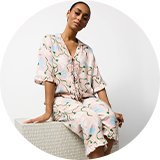 Woman modelling floral pyjamas from the women’s nightwear range.