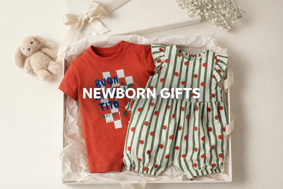 Newborn gift set with baby outfit and essentials wrapped for gifting.