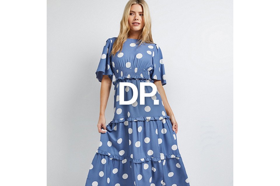 Person wearing a blue maxi dress with large white polka dots and tiered ruffle layers.