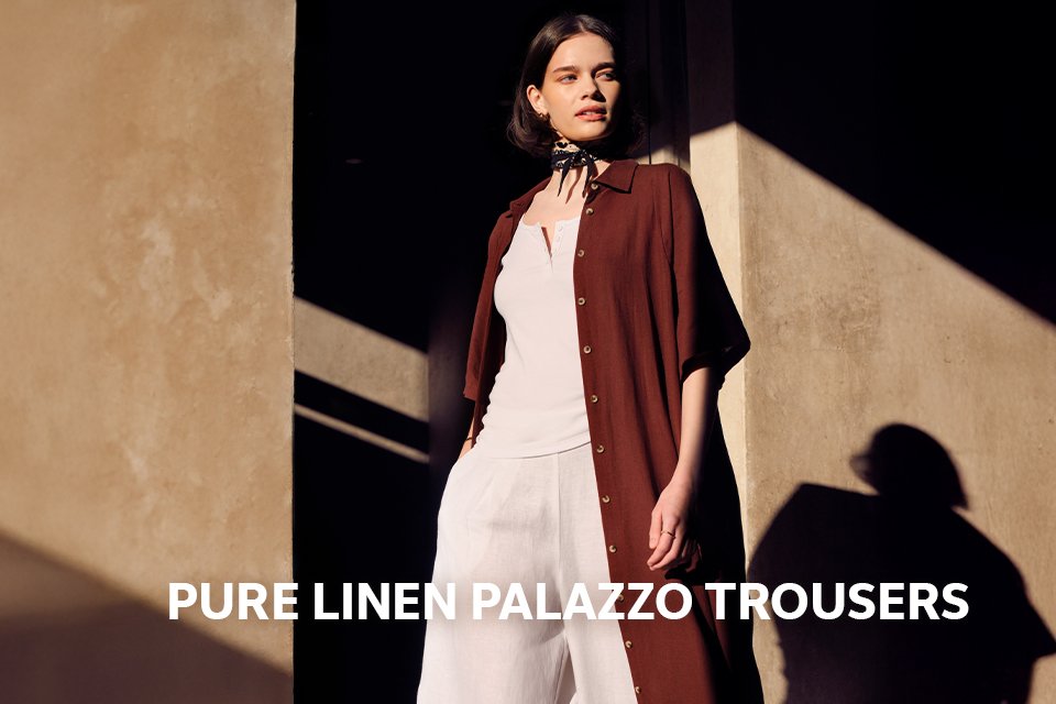 Woman wearing white co-ord with a longline open shirt.