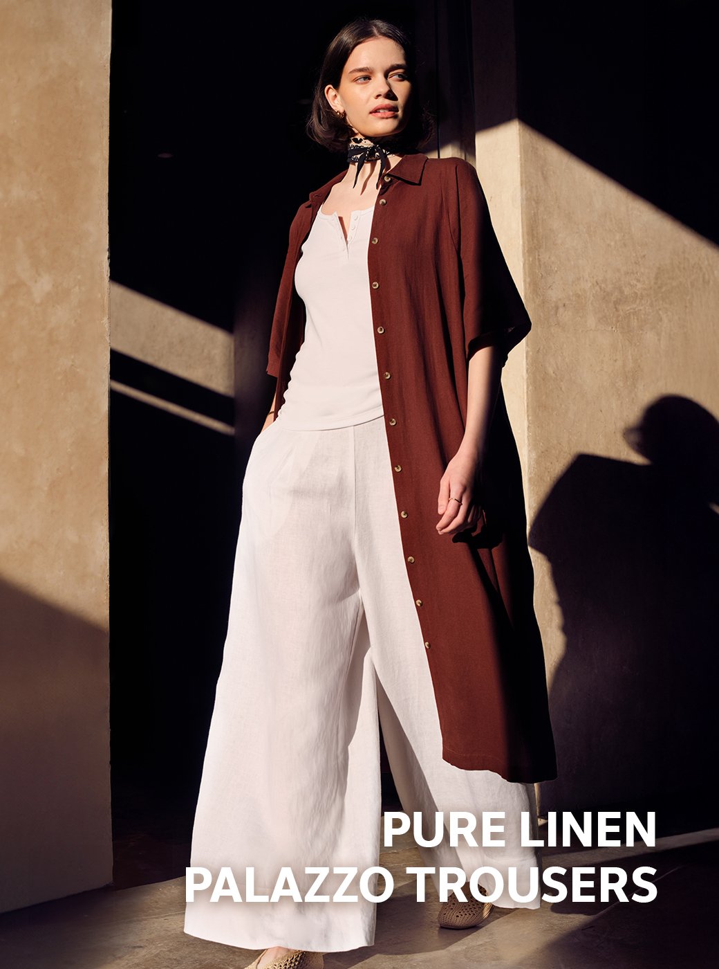 Woman wearing white co-ord with a longline open shirt.