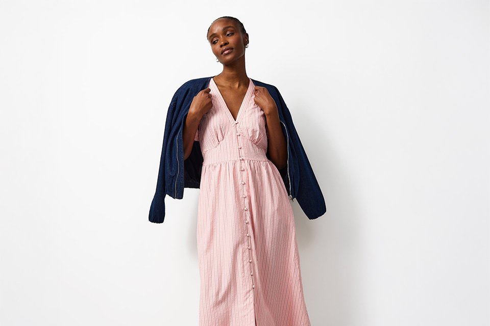 Lightweight pink midi dress layered with a jacket, styled as a festival outfit for changeable weather.