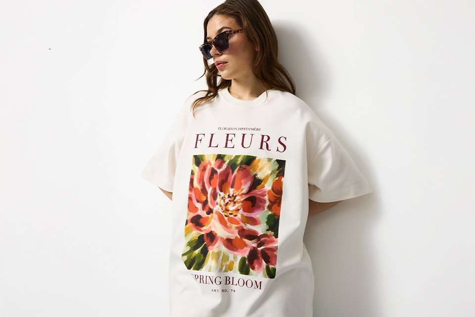 Oversized white graphic festival T-shirt styled as a relaxed festival outfit, ideal for casual summer dressing.