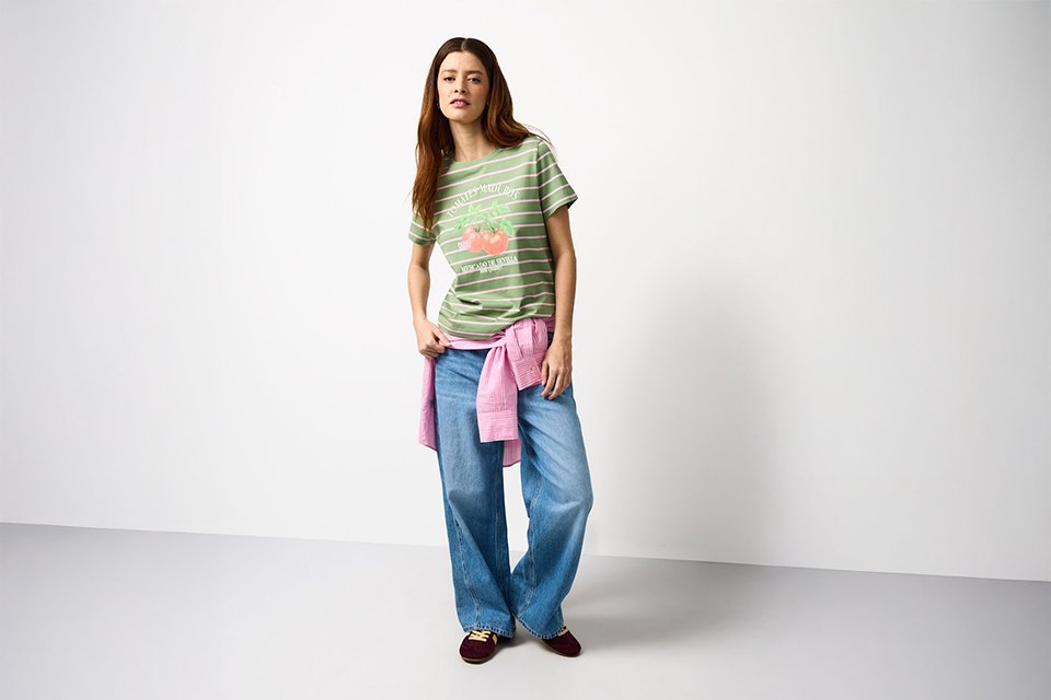 Striped festival T-shirt styled with wide-leg jeans, showcasing a versatile festival capsule outfit.