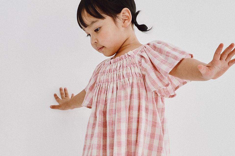 Children’s wedding guest outfit featuring a lightweight pink check dress designed for comfort and smart occasion wear.