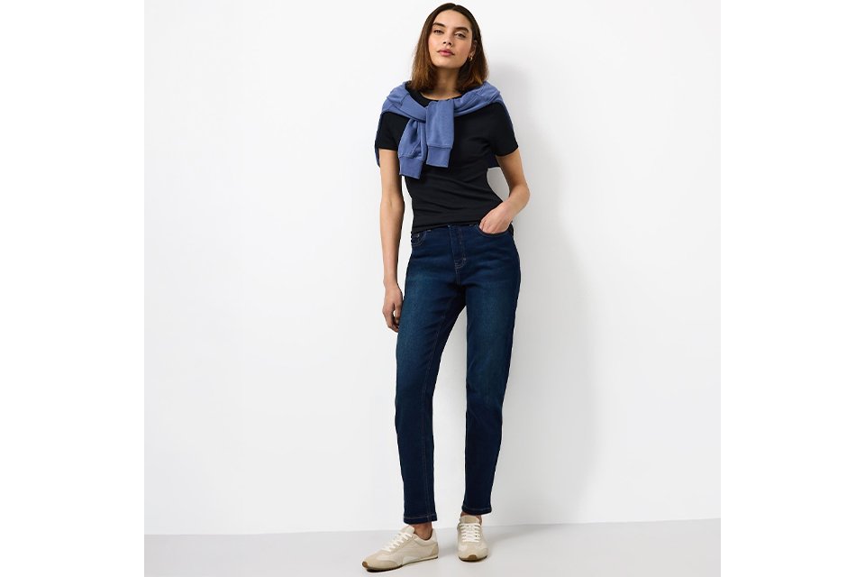 Denim dungarees styled with navy T-shirt for practical countryside staycation outfit.