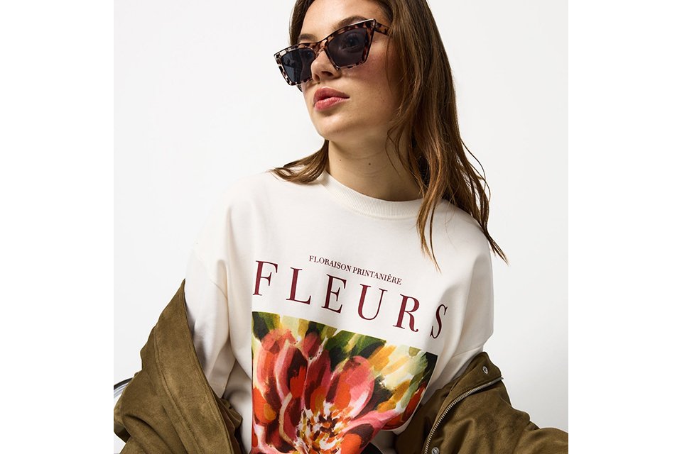 Graphic slogan T-shirt styled with casual jacket for relaxed city break outfit.