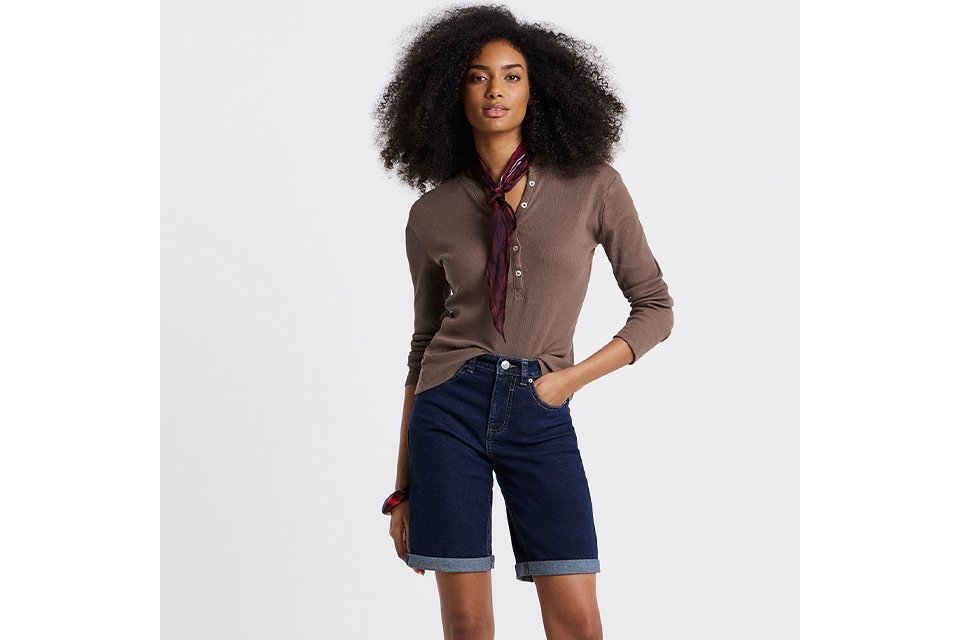 Brown long sleeve top styled with denim shorts and belt for coastal holiday outfit ideas.