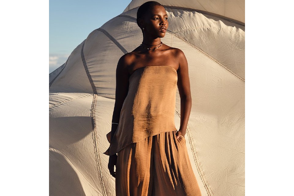 Woman wearing a co-ord with strapless top and balloon trousers.