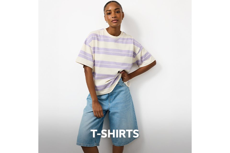Woman wearing a lilac and cream strip t-shirt with light denim jorts.