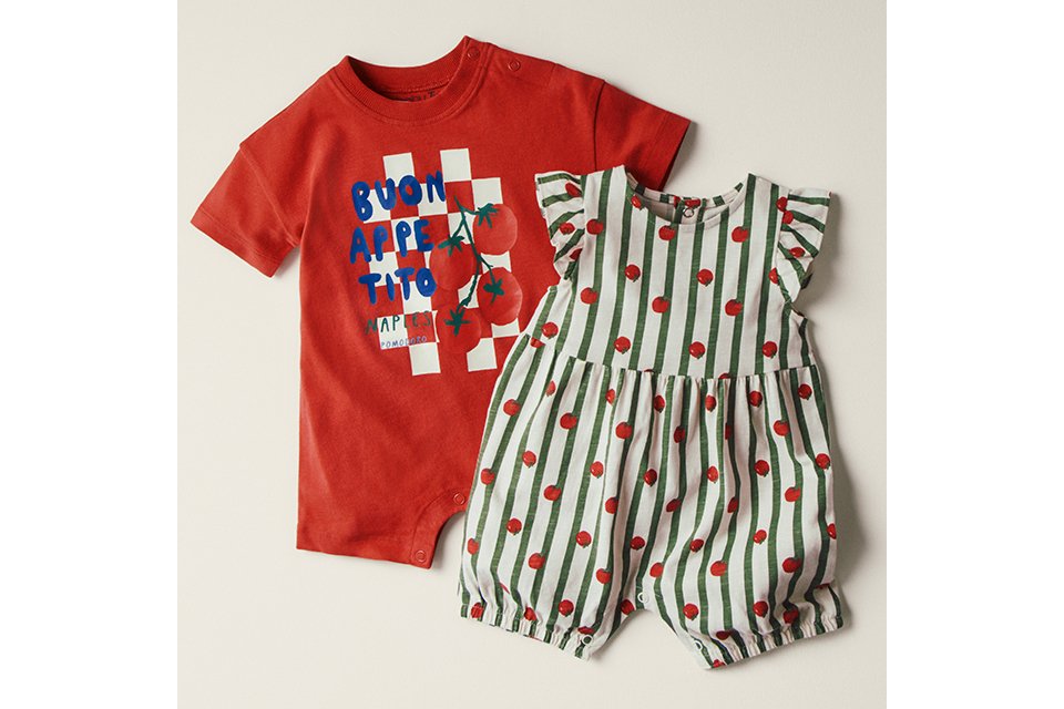 A flat lay shot of 2 baby rompers featuring tomato prints.