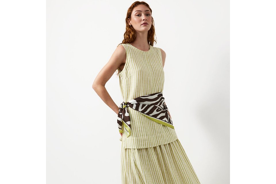 Woman wearing a pale green and cream stripe maki skirt and top.