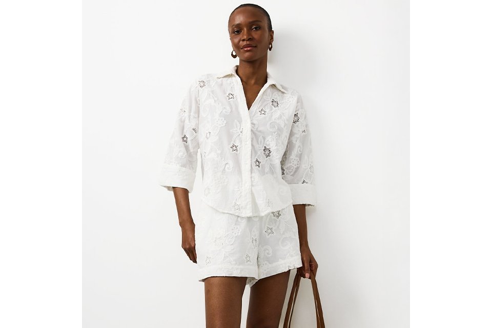 Woman wearing a white two piece lace co-ord set.
