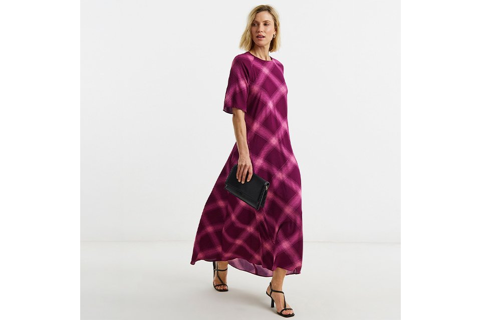 Woman wearing a pink and purple maxi dress with heels.