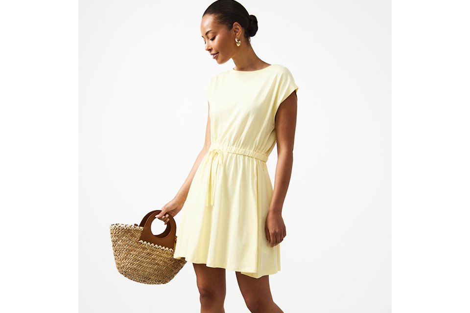 Woman wearing a butter yellow mini dress.
