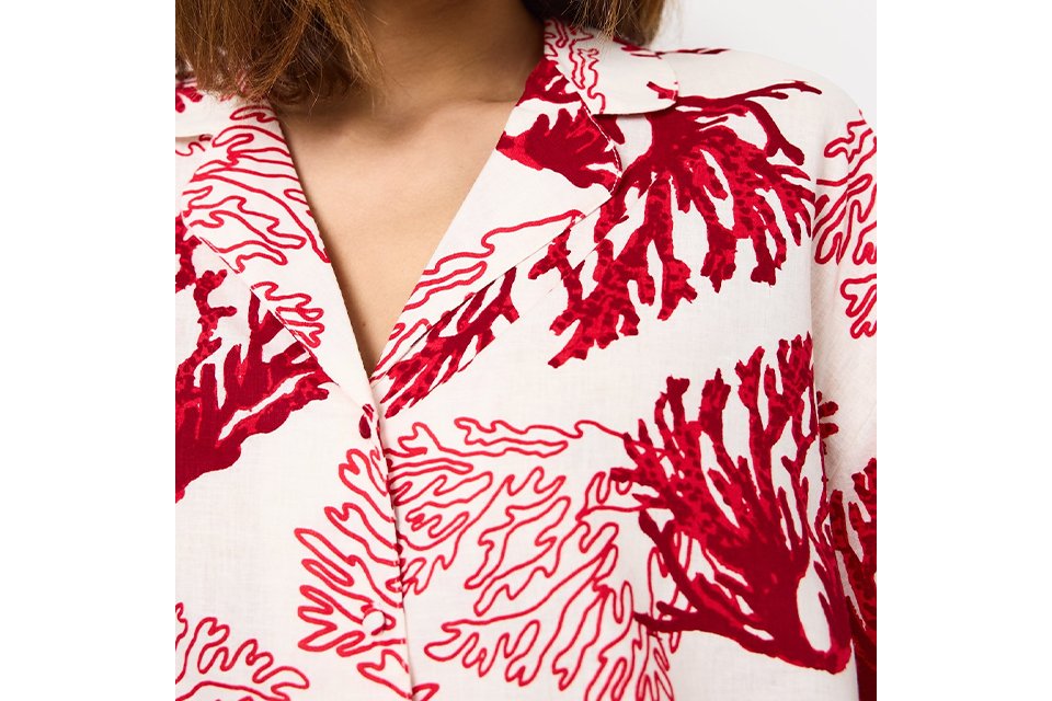 White collared blouse featuring a bold red coral-inspired print with a relaxed, elegant silhouette.