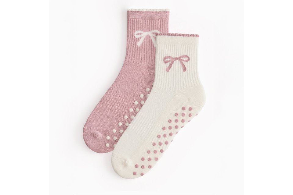 Pack of two ribbed ankle socks in pink and cream featuring bow motifs and non-slip grip soles.