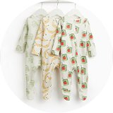 Set of three baby footed sleepsuits featuring playful fruit-inspired prints, including banana, apple juice carton and milk carton designs.