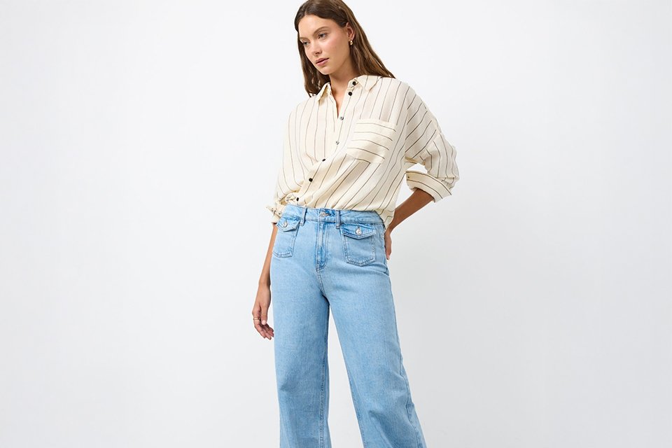 Cream striped button-through shirt with rolled sleeves, styled with light wash wide-leg jeans for a relaxed smart-casual look.
