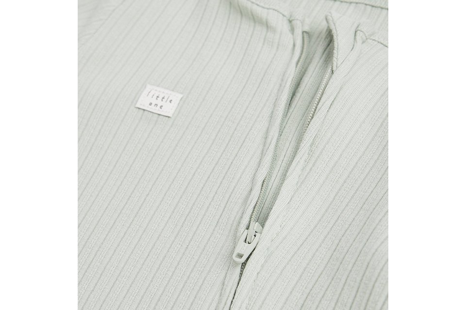 Close-up of a sage green ribbed baby sleepsuit with front zip fastening, crafted from soft stretch fabric for comfortable newborn and infant wear.