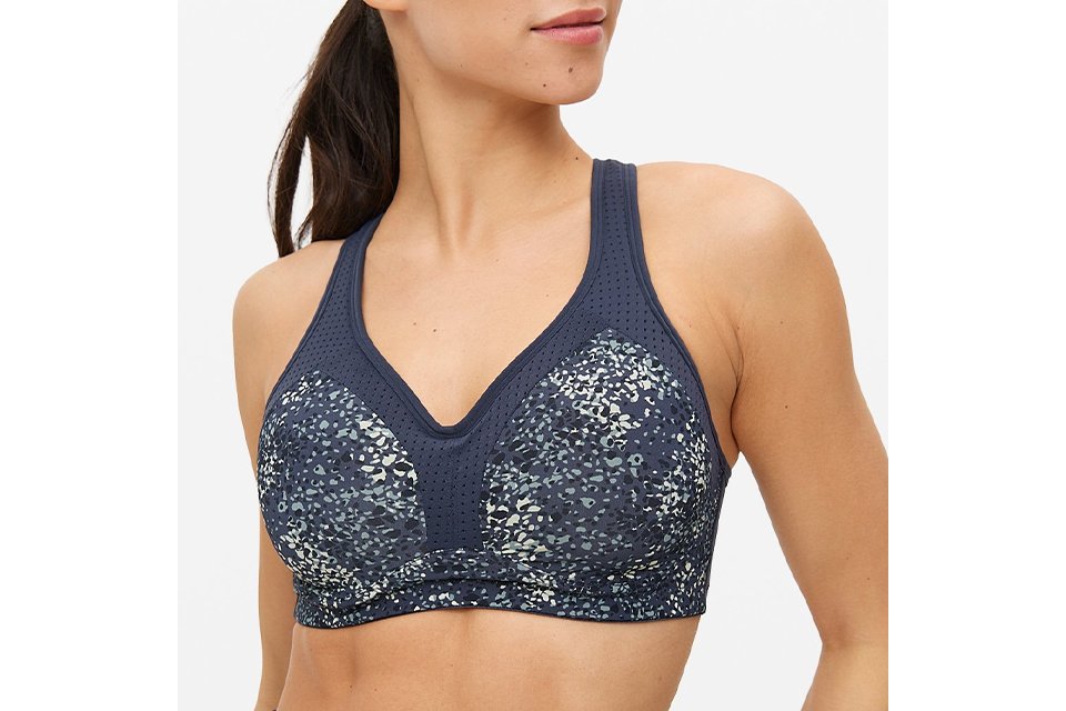 A woman wearing a blue-grey pattered sports bra.