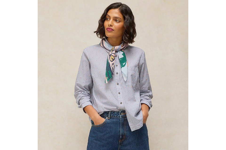 Striped button-down shirt with printed neck scarf, wide-leg cuffed jeans, and brown suede loafers.