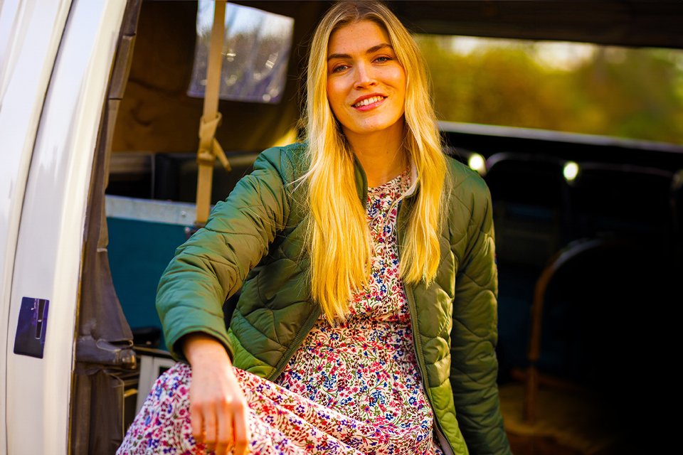 Woman in Brakeburn patterned dress and green coat.