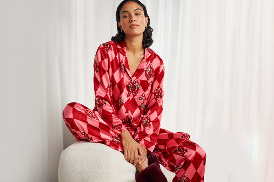 Women wearing pink and red bow pyjamas.