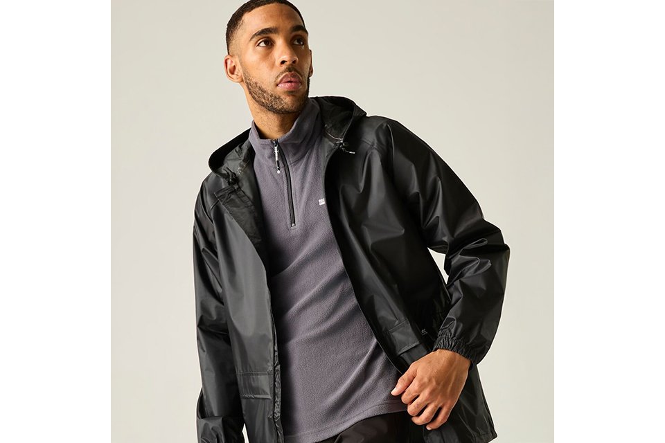 Men's lightweight black jacket layered over knitwear for versatile autumn layering outfits.