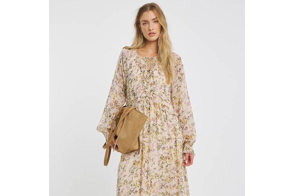 Light-colored floral maxi dress with long sleeves and a flowing hem.
