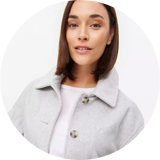 Woman wearing light grey boxy jacket.