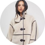 Woman wearing cream shearling coat.