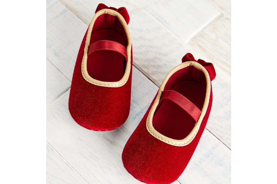 Red baby shoes with gold trim for cute Christmas party look.