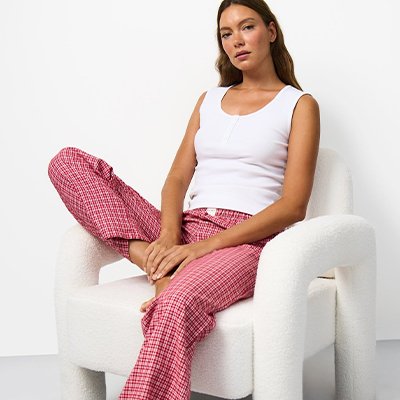 Women's pyjama separates featuring a white vest top and pink checked lounge trousers, mix-and-match nightwear.