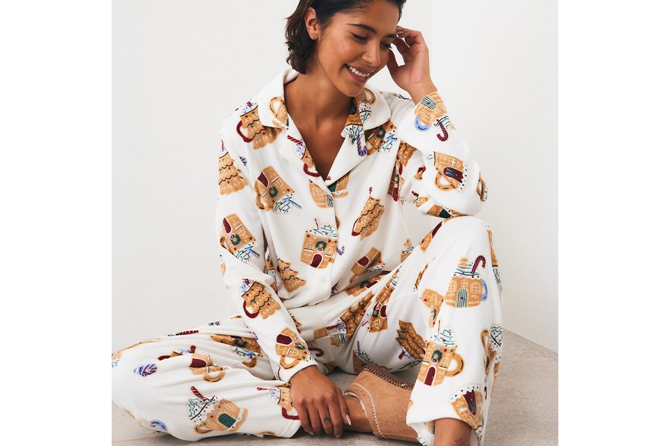 Person wearing food-themed Christmas pyjamas featuring festive treats and novelty seasonal prints.