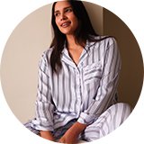 Person relaxing in striped Christmas pyjamas for a cosy festive movie night at home.