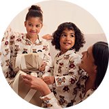 Family wearing matching Christmas pyjamas in festive seasonal prints.