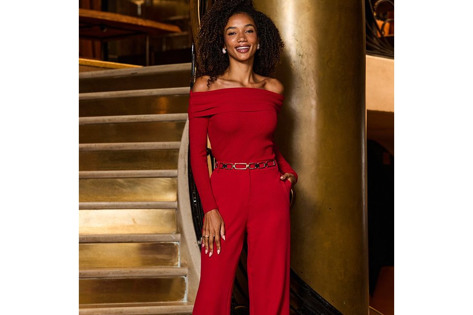 Women's red bardot jumpsuit featuring a ribbed knit texture, long sleeves and wide-leg silhouette.