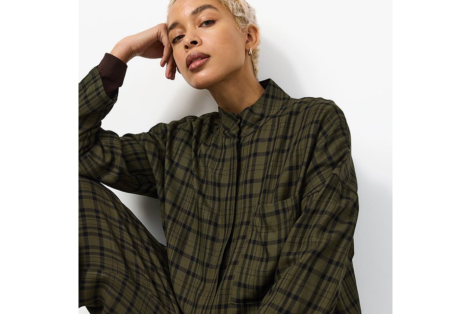 A woman wearing a green check funnel shacket.