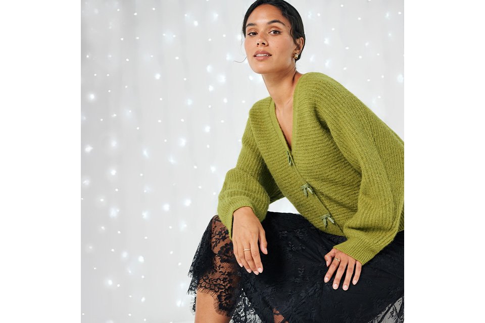 Green chunky knit jumper paired with black lace skirt for a chic winter outfit.