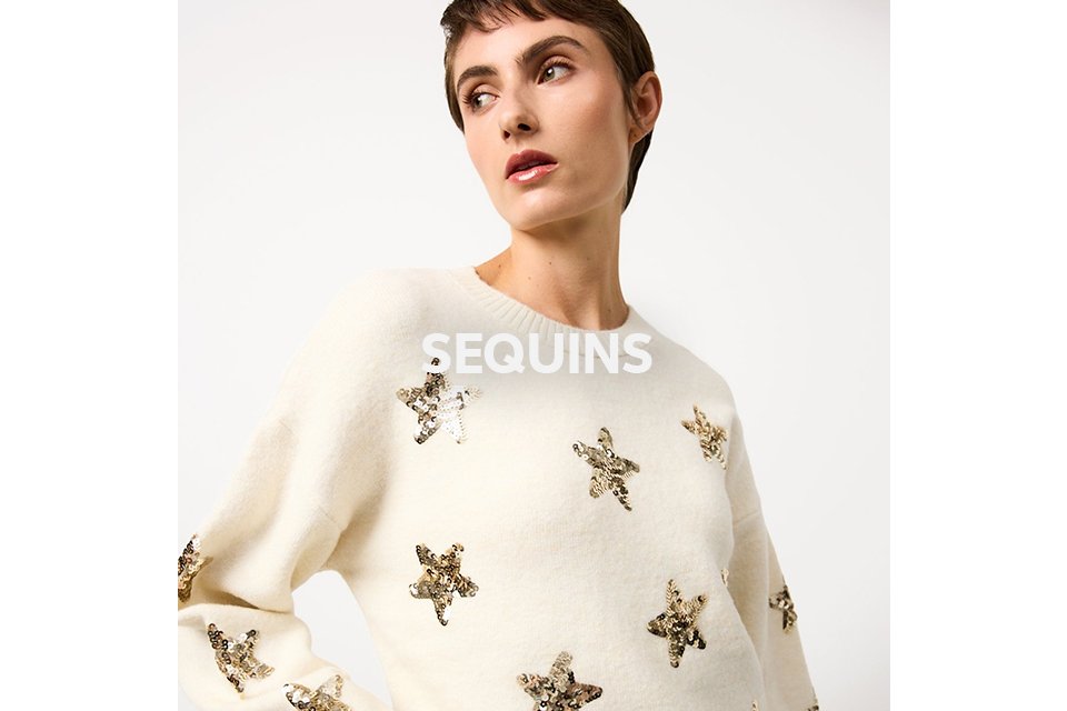 Woman wearing cream star sequin embellished jumpers.